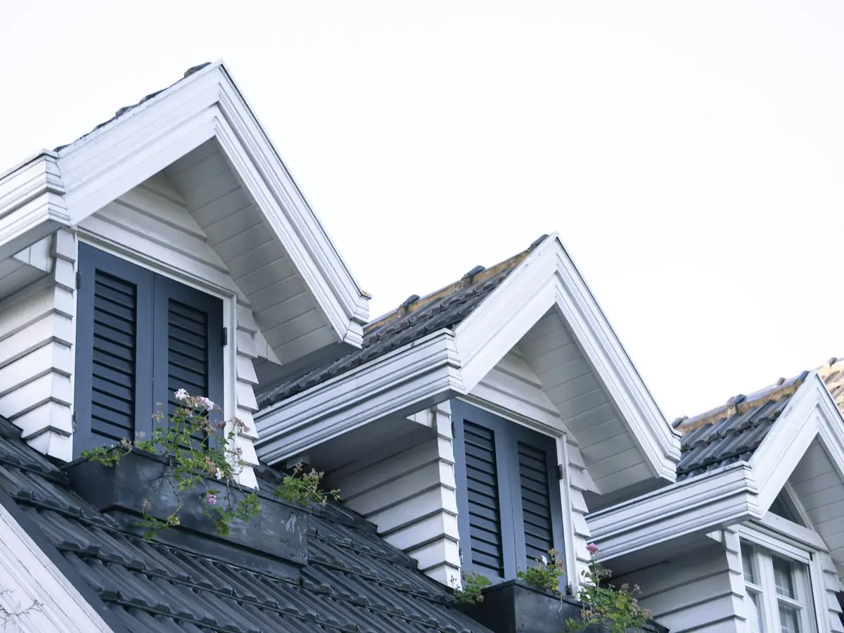 Gabled rooflines of attached townhomes with white siding